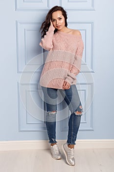 Beautiful cute girl with a smile demonstrates knitted clothes