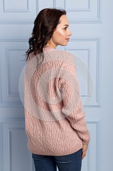 Beautiful cute girl with a smile demonstrates knitted clothes