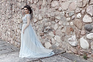 Beautiful cute happy girl bride in light wedding dress walking in the park