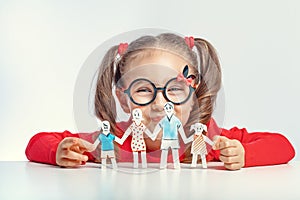 Beautiful cute little girl holding paper cut out of people