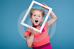 Beautiful cute little girl in pink dress holds picture frame