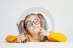 Beautiful cute little preschooler girl holding colorful pencils and making gesture while looking at cameraBeautiful cute little pr