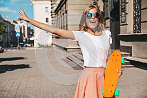Beautiful cute smiling blond teenager model in summer hipster clothes