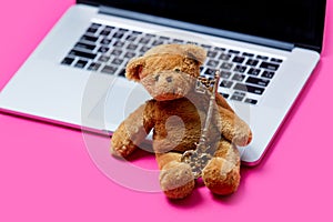 Beautiful cute teddy bear with golden key and cool laptop on the