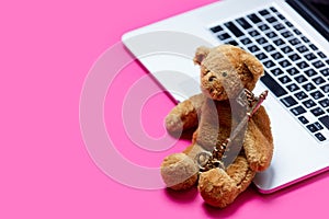 Beautiful cute teddy bear with golden key and cool laptop on the