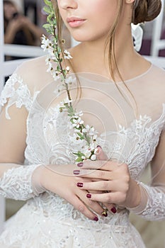 Beautiful cute tender young girl bride in wedding dress in mirrors with evening hair and gentle light make-up