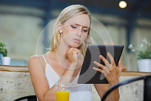 Beautiful cute young businesswoman in cafe using digi photo