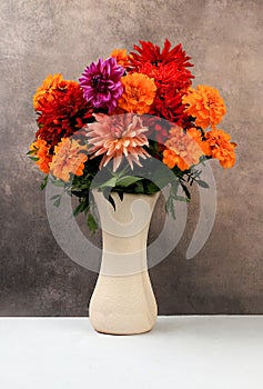 Beautiful dahlia flowers in a vase, abstract floral arrangement, autumn background with space for text, minimal holiday concept,