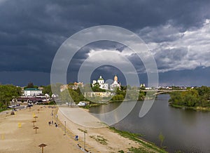 Beautiful dark blue thundercloud over the city. Top view of the city, churches, bridge, river. Aerial photography.