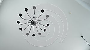 A beautiful dark chandelier with twelve/12 plafonds hangs on the ceiling