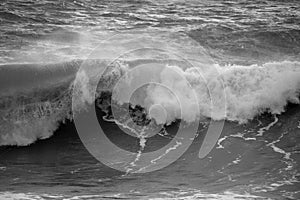 Beautiful dark dramatic toned fine art seascape image of breaking waves on Atlantic Ocean in Devon England