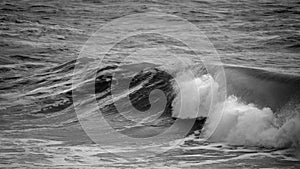 Beautiful dark dramatic toned fine art seascape image of breaking waves on Atlantic Ocean in Devon England