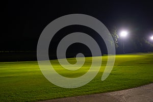 Beautiful dark night view of the golf course, Bunkers sand and green grass, garden background In the light of the spotlight