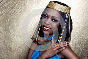 Beautiful dark-skinned girl black woman in the image of the Egyptian queen with red lips bright makeup demonstrates long nails photo