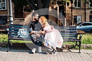 Beautiful dating couple hugging on a bench