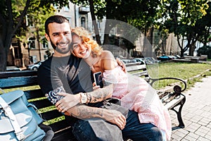 Beautiful dating couple hugging on a bench