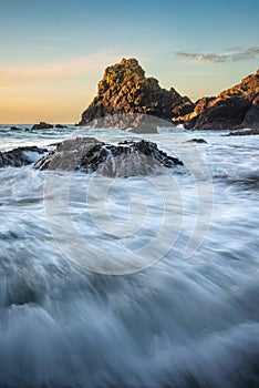 Beautiful dawn landscape over Kynance Cove in Cornwall England with vibrant sky and beautiful turquoise ocean