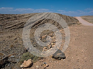 Beautiful day on adventure road trip through desert rock mountain texture landscape route to emptiness with blue sky copyspace