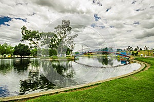 Beautiful day of an artificial lake located in the midle of a park, with the reflection in the water, in the city of