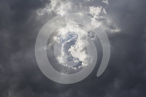 Beautiful day cloudscape view from below of dramatic dramatic grey and white thunder storm clouds on a dark sky background