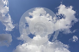 Beautiful day cloudscape view from below of fluffy dramatic white and grey clouds on a deep blue sky background