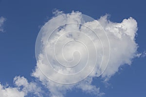 Beautiful day cloudscape view from below of fluffy dramatic white and grey clouds on a deep blue sky background