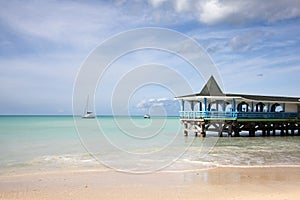 Beautiful day with a view out to sea & the pier of Runaway Beach, Antigua, Caribbean