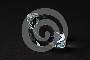 Beautiful dazzling diamond on dark background, closeup. Precious gemstone