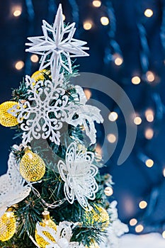 Beautiful decorated christmas tree with snow on the blurred bokeh of the garland. Holiday background