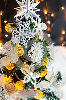 Beautiful decorated christmas tree with snow on the blurred bokeh of the garland. Holiday background