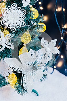 Beautiful decorated christmas tree with snow on the blurred bokeh of the garland. Holiday background