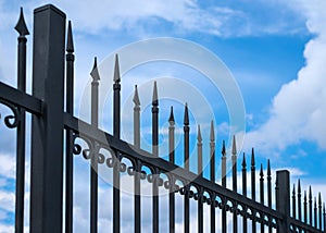 Beautiful decorative cast metal wrought fence against blue sky. Iron guardrail close up