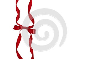 Decorative silk red ribbon with a bow on isolated white background.