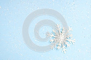 Beautiful decorative snowflake on white snow. blue background with space for text, greeting christmas card