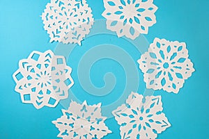 Beautiful decorative snowflakes cutted from paper on a blue background. Photo for Christmas and New Year