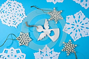 Beautiful decorative snowflakes little angel cut out of paper on a blue background. Photo for Christmas and New Year design