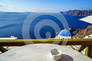 Beautiful deep blue Aegean ocean panoramic sea view and blue church roof from breakfast coffee shop with white marble table
