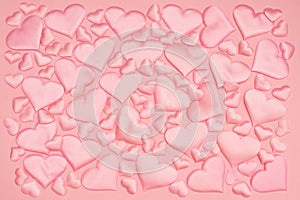 beautiful delicate background of voluminous pink satin hearts of different sizes arranged in the style of puzzles