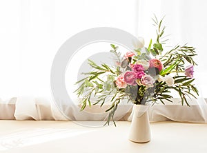 Beautiful delicate flower bouquet with roses, eustomas and eucalyptus leaves in a vase on a windowsill