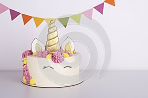 Beautiful delicate unicorn birthday cake on a white table. festive sweet treat