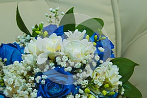 Beautiful delicate wedding bouquet of blue roses and wedding rings of the bride and groom.