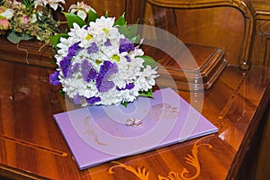 Beautiful delicate wedding bouquet white chrysanthemums and wedding rings of the bride and groom