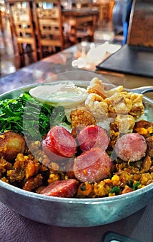 Platter of tropeiro beans, with egg, cabbage and pork rinds photo