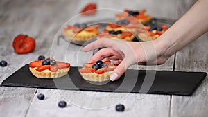 Beautiful delicious summer tartlets with fresh custard creamy filling topped with strawberry and blueberry.