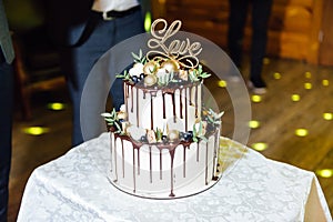 Beautiful delicious white wedding cake at the evening