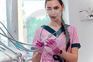 Beautiful dentis in pink uniform looking at the camera