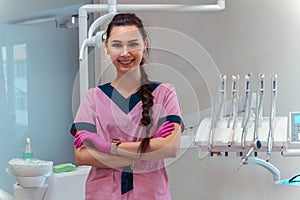Beautiful dentis in pink uniform smiles on camera