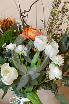 Beautiful designer airy winter bouquet of flowers with Christmas decorations, close-up. It is composed of eucalyptus, ranunculus,