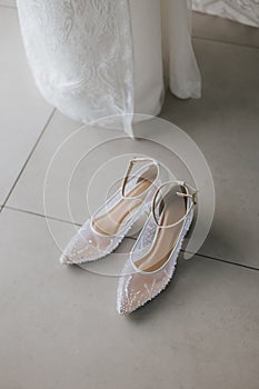 Beautiful detail close up white woman wedding shoes at the floor