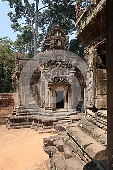 Beautiful, detailed murals on ancient temple ruins, religon symbols in angkor wat on red brown sand, trees in background